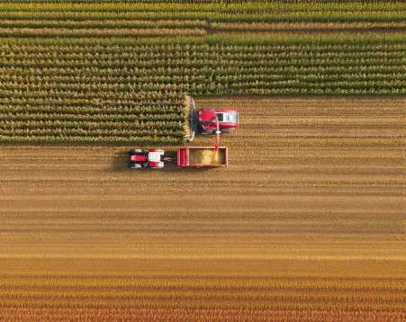 Tractors harvesting a field, aerial view